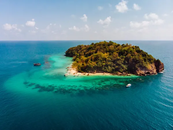 Turquoise waves washing onto the white sand of Coral Island